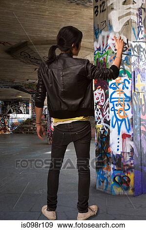 A young man spraying graffiti View Large Photo Image Stock Photo - A young man spraying graffiti. Fotosearch