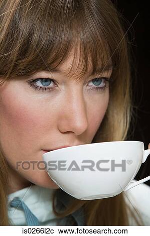 Stock Image - A young woman having a cup of tea. Fotosearch