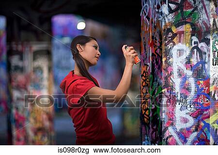 A young woman spraying graffiti View Large Photo Image Stock Image - A young woman spraying graffiti. Fotosearch