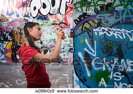 A young woman spraying graffiti View Large Photo Image Stock Photo - A young woman spraying graffiti. Fotosearch