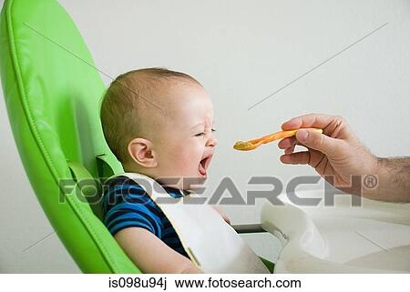 Stock Image - Baby being fed. Fotosearch