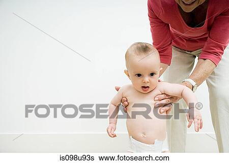 Baby being helped to stand View Large Photo Image Stock Photograph - Baby being helped to stand. Fotosearch