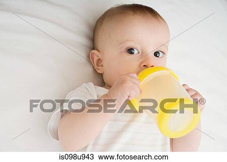 Stock Image - Baby drinking from bottle. Fotosearch