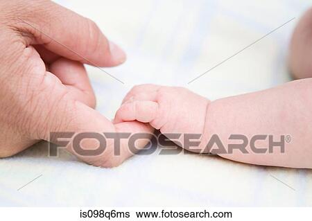 Stock Photograph - Baby holding adult finger. Fotosearch