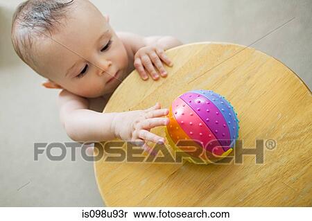 Stock Photography - Baby reaching for toy. Fotosearch