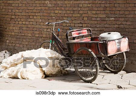 Stock Photography - Bicycle next to pile of wool on footpath. Fotosearch