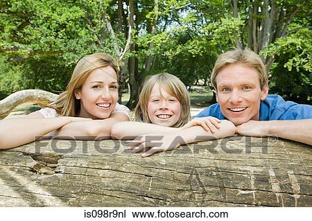 Stock Image - Boy and parents by log. Fotosearch