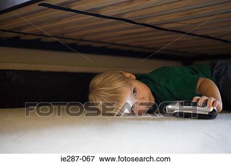 Stock Photo - Boy hiding under bed. Fotosearch