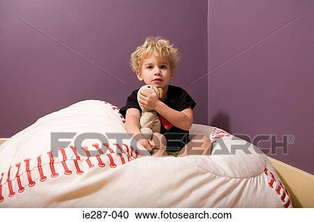 Stock Image - Boy in bed with teddy bear. Fotosearch