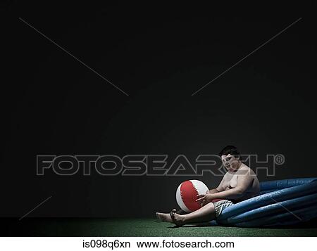Picture - Boy in paddling pool with beach ball. Fotosearch