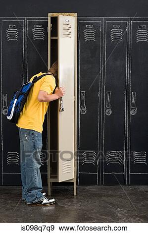 Stock Photo - Boy looking in locker. Fotosearch