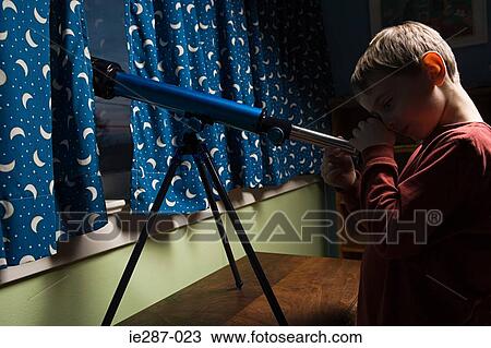 Boy looking through a telescope View Large Photo Image Stock Image - Boy looking through a telescope. Fotosearch