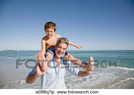 Stock Photography - Boy on fathers shoulders by the sea. Fotosearch