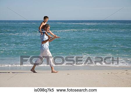 Stock Photography - Boy on fathers shoulders by the sea. Fotosearch