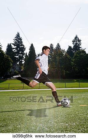Stock Image - Boy playing football. Fotosearch