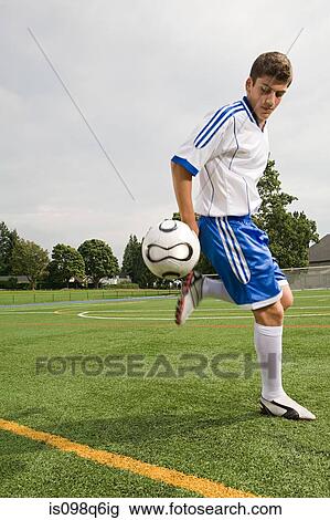 Stock Image - Boy playing football. Fotosearch