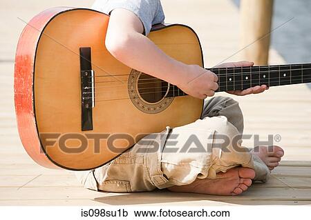 Stock Image - Boy playing guitar. Fotosearch