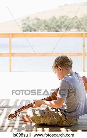 Stock Image - Boy playing guitar. Fotosearch