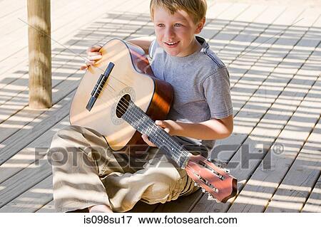 Stock Photo - Boy playing guitar. Fotosearch