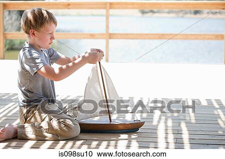 Boy playing with toy boat View Large Photo Image Stock Image - Boy playing with toy boat. Fotosearch