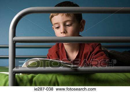 Boy reading on bed View Large Photo Image Stock Photo - Boy reading on bed. Fotosearch