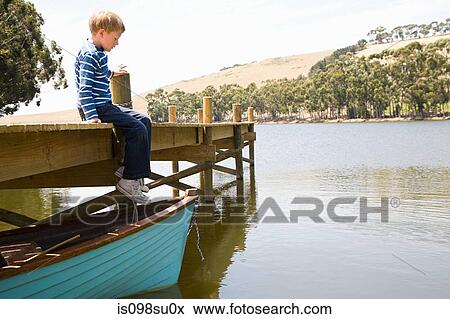Boy sitting alone on jetty View Large Photo Image Stock Photo - Boy sitting alone on jetty. Fotosearch