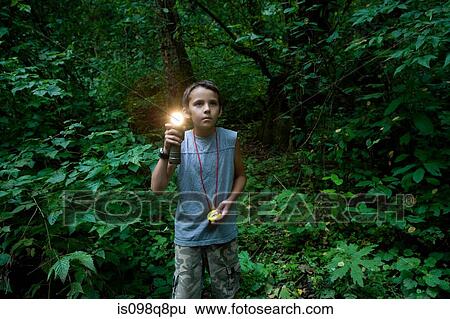 Stock Photograph - Boy with torch in forest. Fotosearch