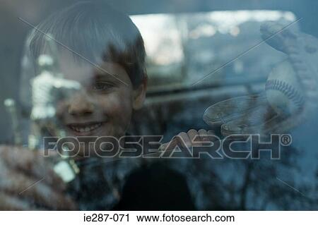 Stock Image - Boy with trophy through window. Fotosearch