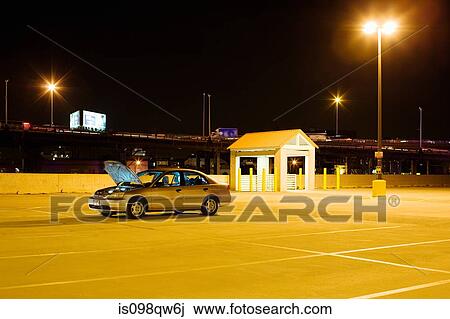 Stock Image - Broken down car in parking lot. Fotosearch