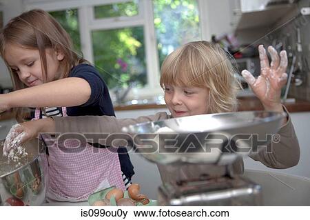 Stock Photo - Brother and sister baking together. Fotosearch