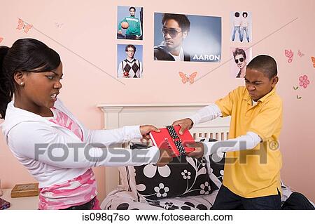 Picture - Brother and sister fighting over a diary. Fotosearch