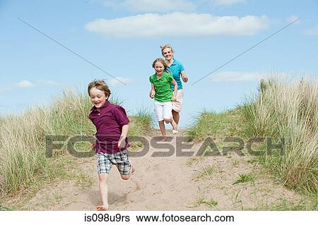 Stock Photograph - Brother and sisters running to the beach. Fotosearch