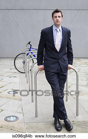 Stock Image - Businessman by bicycle rack. Fotosearch