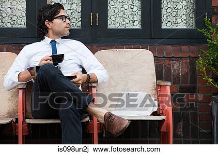 Stock Image - Businessman outside coffee shop. Fotosearch