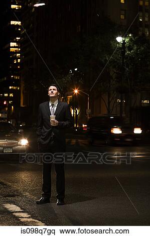 Stock Photography - Businessman standing in a road at night. Fotosearch