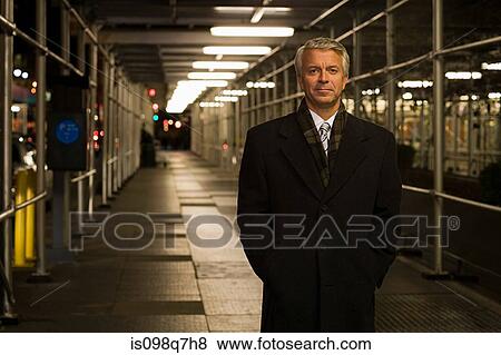 Stock Photo - Businessman standing in a walkway. Fotosearch