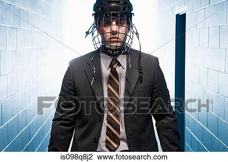 Stock Image - Businessman wearing an ice hockey helmet. Fotosearch