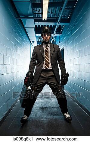 Stock Image - Businessman wearing ice hockey uniform. Fotosearch