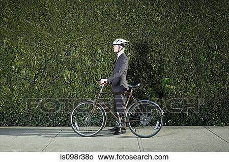Businessman with bicycle and helmet View Large Photo Image Picture - Businessman with bicycle and helmet. Fotosearch