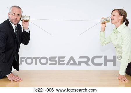 Businesspeople using a tin can telephone View Large Photo Image Stock Photograph - Businesspeople using a tin can telephone. Fotosearch