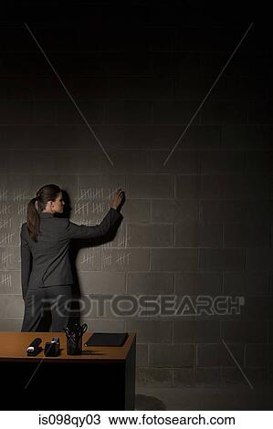 Stock Image - Businesswoman and chalk marks on wall. Fotosearch