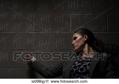 Stock Image - Businesswoman and chalk marks on wall. Fotosearch
