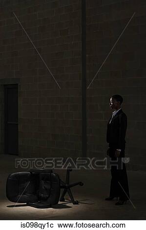 Stock Image - Businesswoman and fallen chair. Fotosearch