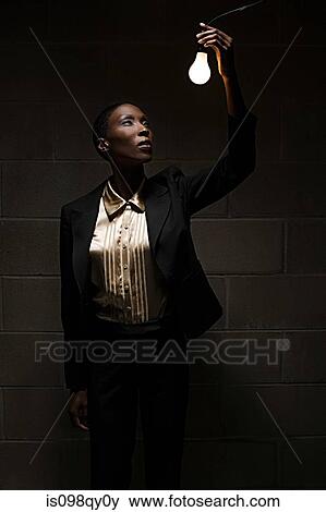 Businesswoman holding lightbulb View Large Photo Image Stock Photo - Businesswoman holding lightbulb. Fotosearch