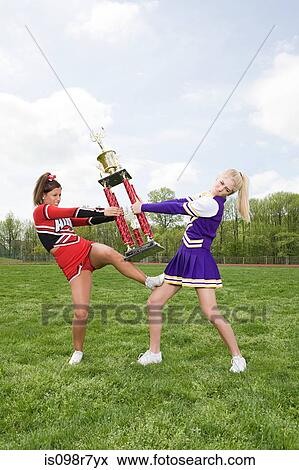 Cheerleaders fighting over trophy View Large Photo Image Stock Photo - Cheerleaders fighting over trophy. Fotosearch