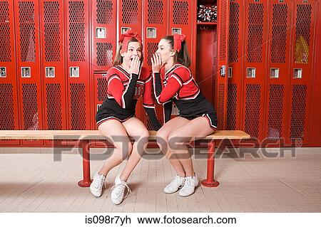 Stock Image - Cheerleaders gossiping in locker room. Fotosearch