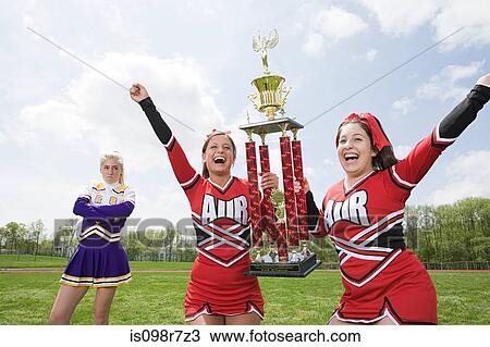 Stock Image - Cheerleaders with trophy. Fotosearch