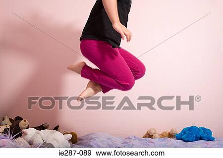 Child jumping on a bed View Large Photo Image Stock Photo - Child jumping on a bed. Fotosearch