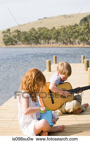 Children sitting on jetty View Large Photo Image Stock Photo - Children sitting on jetty. Fotosearch