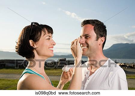Stock Image - Couple applying suntan lotion. Fotosearch
